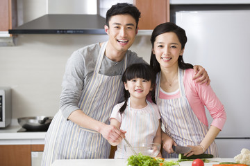 Happy young family cooking in kitchen