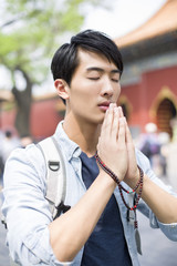 Fototapeta na wymiar Young man praying in the Lama Temple