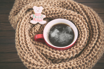 A cup of coffee in a scarf, new year theme, toned