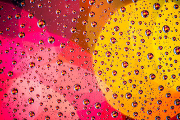 Glass surface covered with water drops. Multicolor background texture.