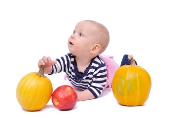 Fototapeta premium child on a white background with pumpkins and apples/charming child with pumpkins and apples; Isolated over White Background