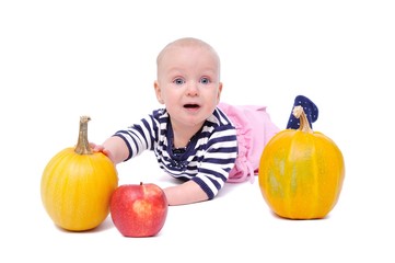 Fototapeta premium child on a white background with pumpkins and apples/charming child with pumpkins and apples; Isolated over White Background