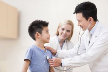Doctor examining little boy with stethoscope