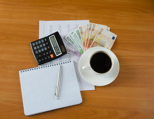 Office supplies with money and cup of coffee
