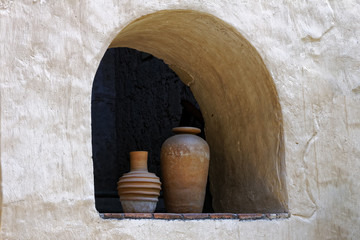 Clay vases in an arched wall recess. © Steven Bramall