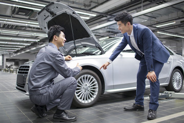 Auto mechanic talking with car owner