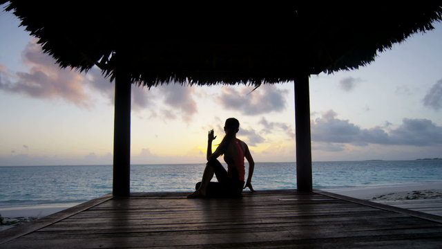 Young girl practicing yoga outdoors at sunrise