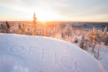 "Out of office" written on snow in winter scenery.