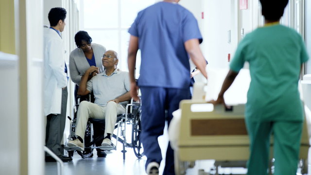 African American disabled senior male on wheelchair and wife in hospital
