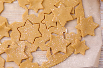 Cutting gingerbread cookies on parchment. Top view.