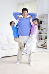 Fototapeta premium Chinese father with children hanging from his arms