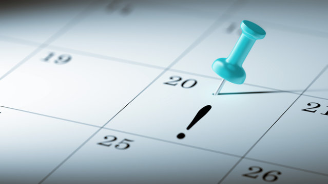 Concept image of a Calendar with a blue push pin. Closeup shot o