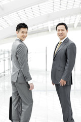 Confident business people in airport lobby