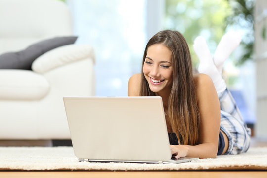 Girl online browsing a laptop at home