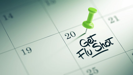 Concept image of a Calendar with a green push pin. Closeup shot