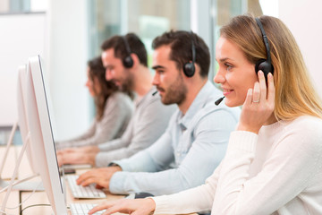 Young attractive woman working in a call center - obrazy, fototapety, plakaty