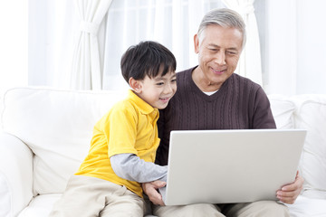 Grandpa and grandson using laptop