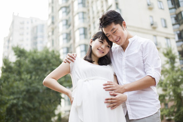 Fototapeta premium Expectant couple touching baby bump