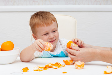 Boy cleans tangerine
