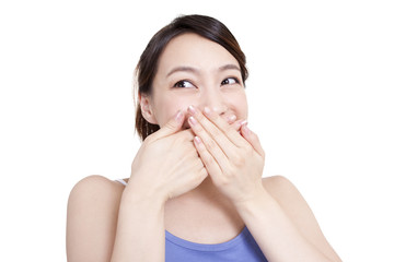 Cute young woman smiling with hands covering mouth
