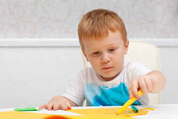 red-haired boy drawing on paper