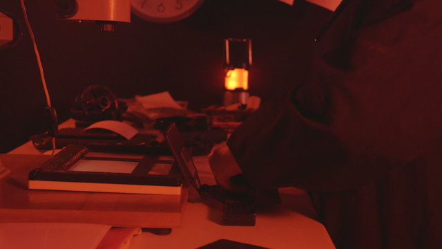 Darkroom printing process photographer using enlarger to produce photographic prints