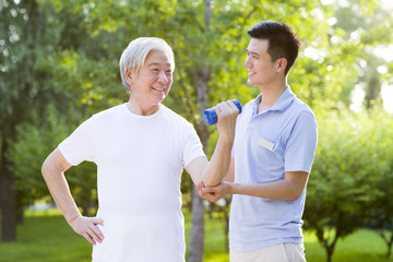 Senior man exercising with dumbbell in nursing home
