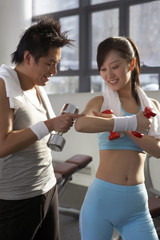 Young Man And Woman Checking Muscles At The Gym