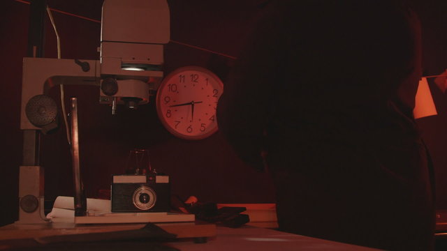 Man photographer working in red photography darkroom