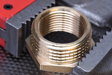 Closeup of brass threaded connector nipple with wrench