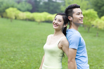 Naklejka premium Sweet young couple listening to music in park