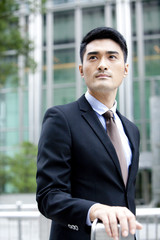 Confident businessman looking at view outside a building, Hong Kong