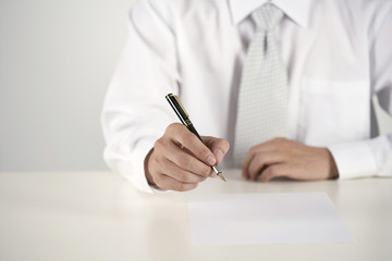A businessman prepares to sign a document