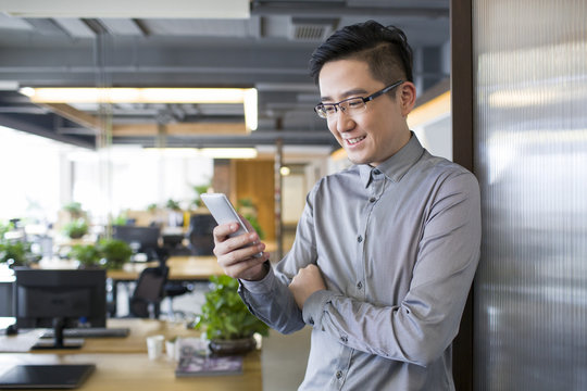 Young man using smart phone in office