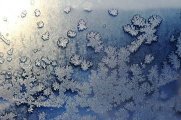 Frozen window covered with frost in winter patterned.