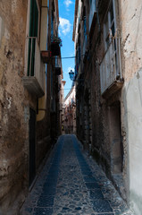 Fototapeta na wymiar Narrow street between italian houses in old town of Tropea