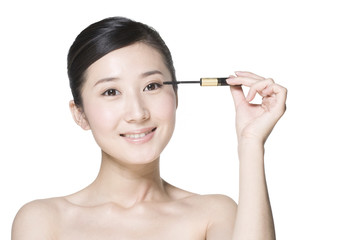 Beauty shot of a young woman applying mascara