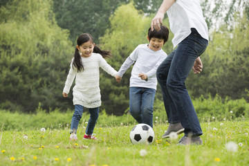 Happy father and children playing football together