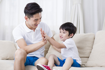 Father and son playing on the sofa