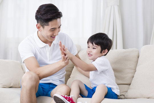Father and son playing on the sofa