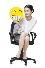 Young businesswoman holding a happy emoticon face