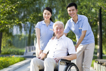 Wheelchair bound man with nursing assistants