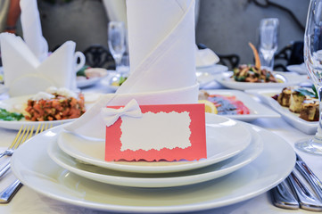 Served banquet table with plates, glasses and dishes