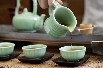 Female hand pouring tea into tea cups