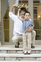 Father and son having fun in front of house