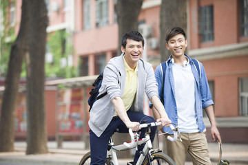 Male college students with bicycle on campus