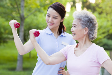 Senior woman exercising with dumbbell in nursing home