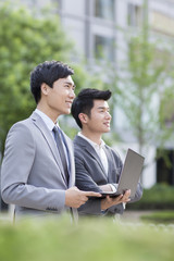 Young business person working with laptop outdoors