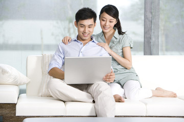 Portrait of a couple using a laptop at home