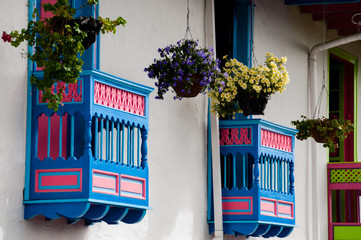 Colorful blue and red house front with flowers on balcony in Salento